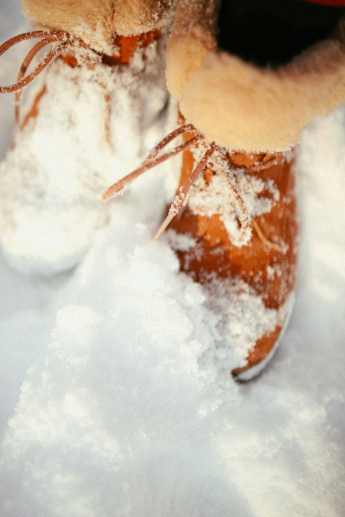 Fur-lined winter boots standing in fresh snow